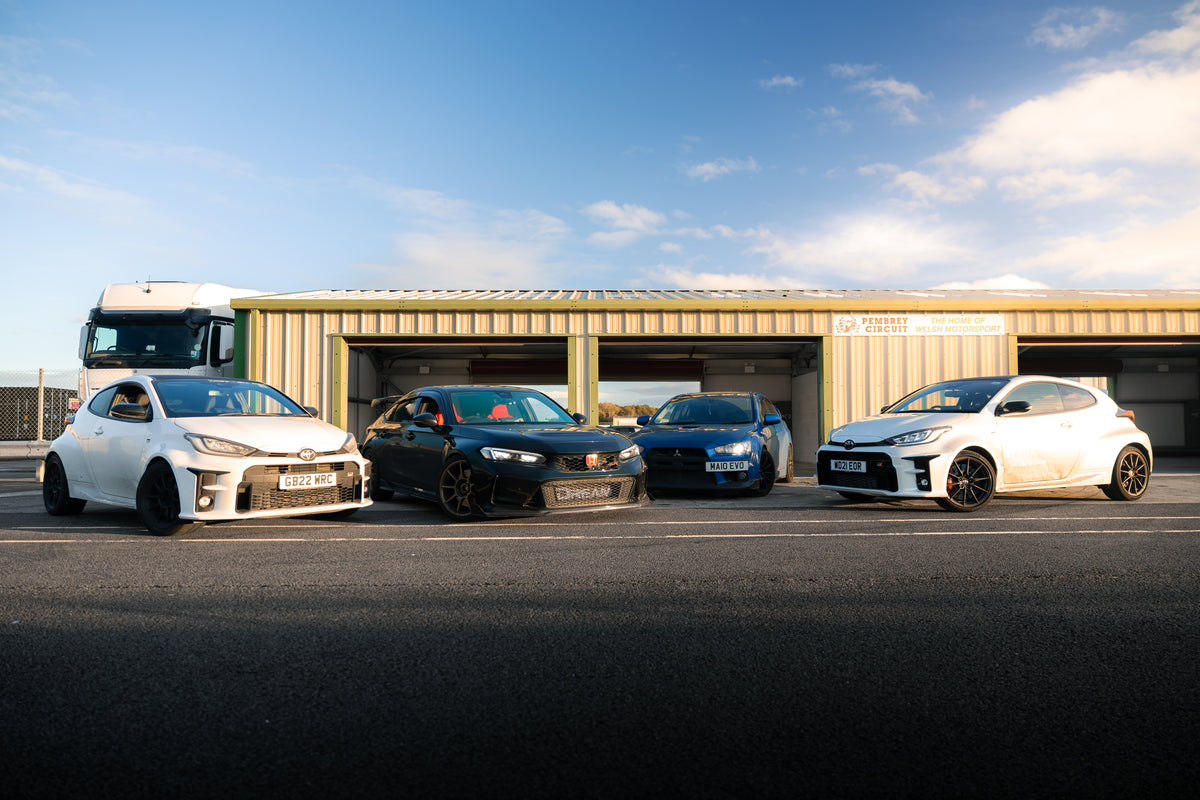 Four cars parked in front of a building with a clear sky.